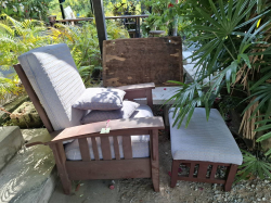 A wooden Chair light blue cushions with A foot rest 