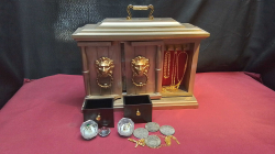 An elegant jewelry box clock, with gold items and coins, working well